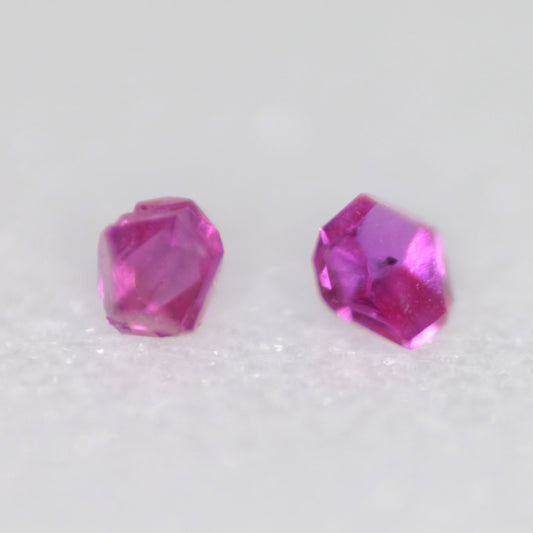 Two flux-grown bright pink synthetic rubies on a white background