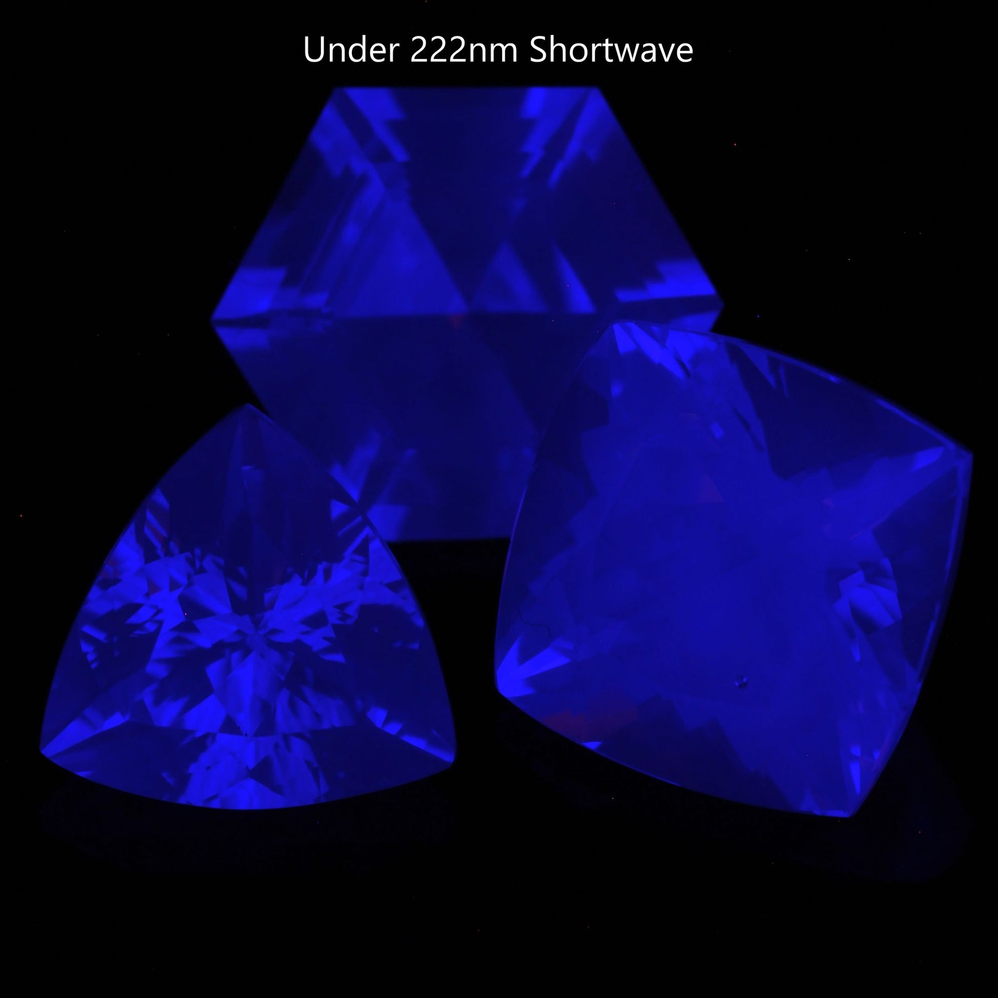 Three Faceted Gemstones cut from clear F-35 Fighter Jet Sapphire Glowing Blue Under Shortwave UV 222nm