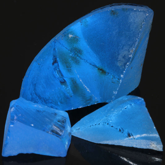 Three pieces of bright blue cobalt spinel, pieces from a czochralski-pulled crystal that are repurposed as gems.