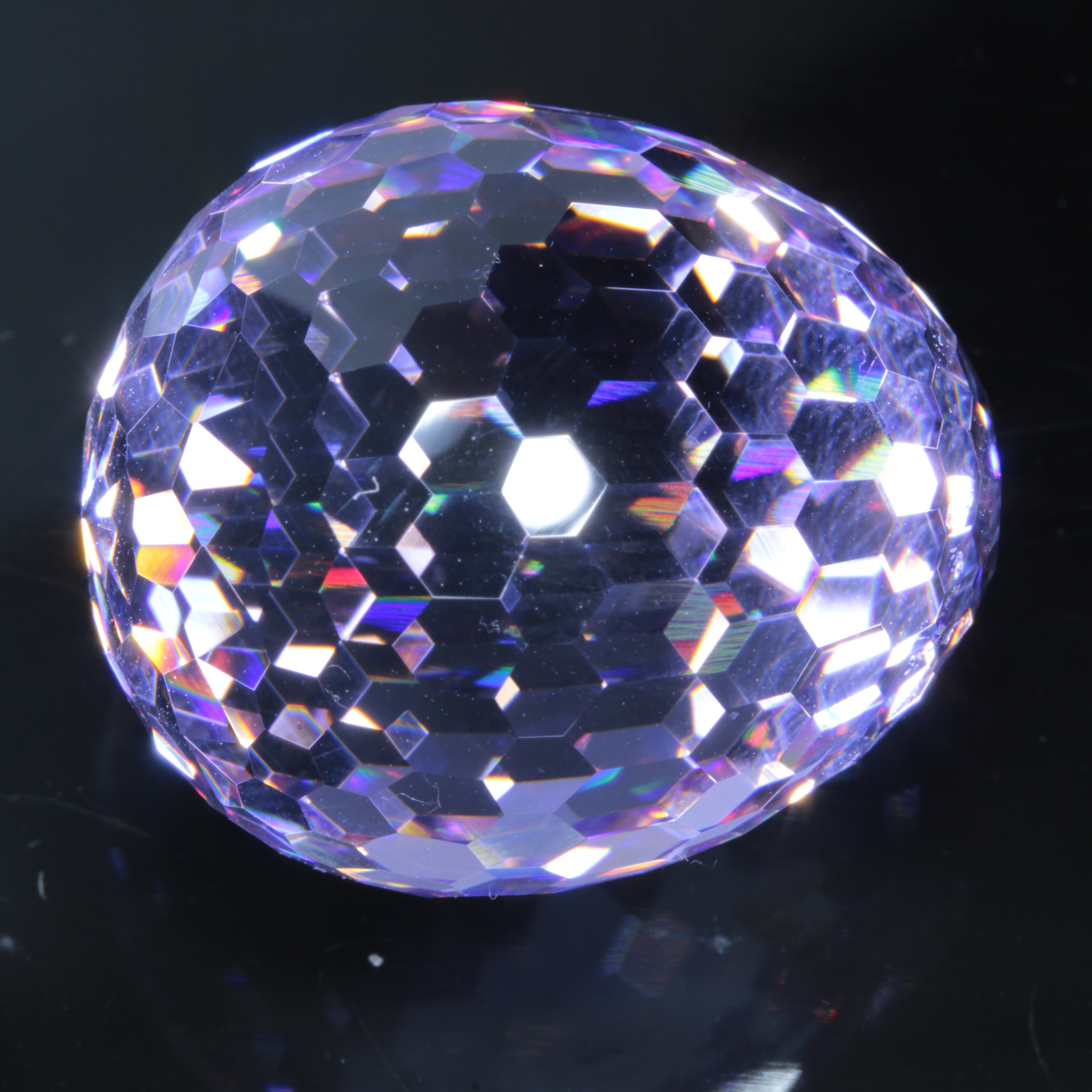 Faceted Nd:YAG Egg Gemstone on a black Background