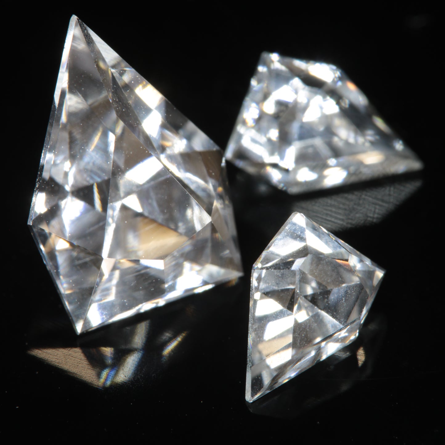 Three faceted gemstones cut from clear F-35 window sapphire, in an EOTS-inspired arrowhead design