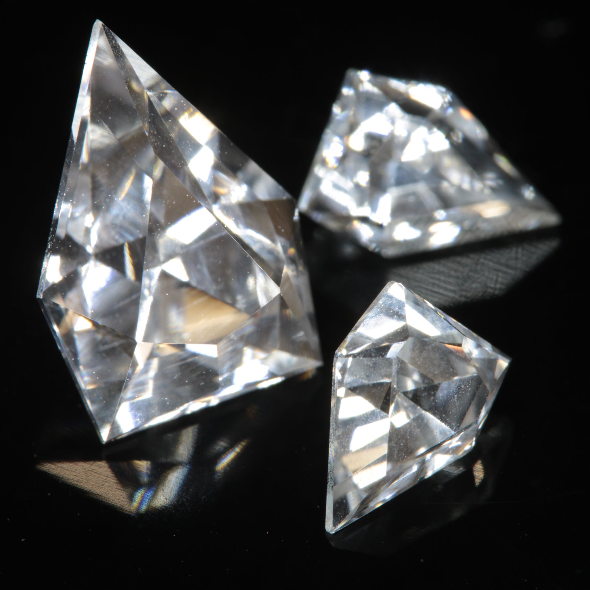 Three faceted gemstones cut from clear F-35 window sapphire, in an EOTS-inspired arrowhead design