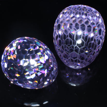 A pair of faceted purple Nd:YAG Eggs on a black background