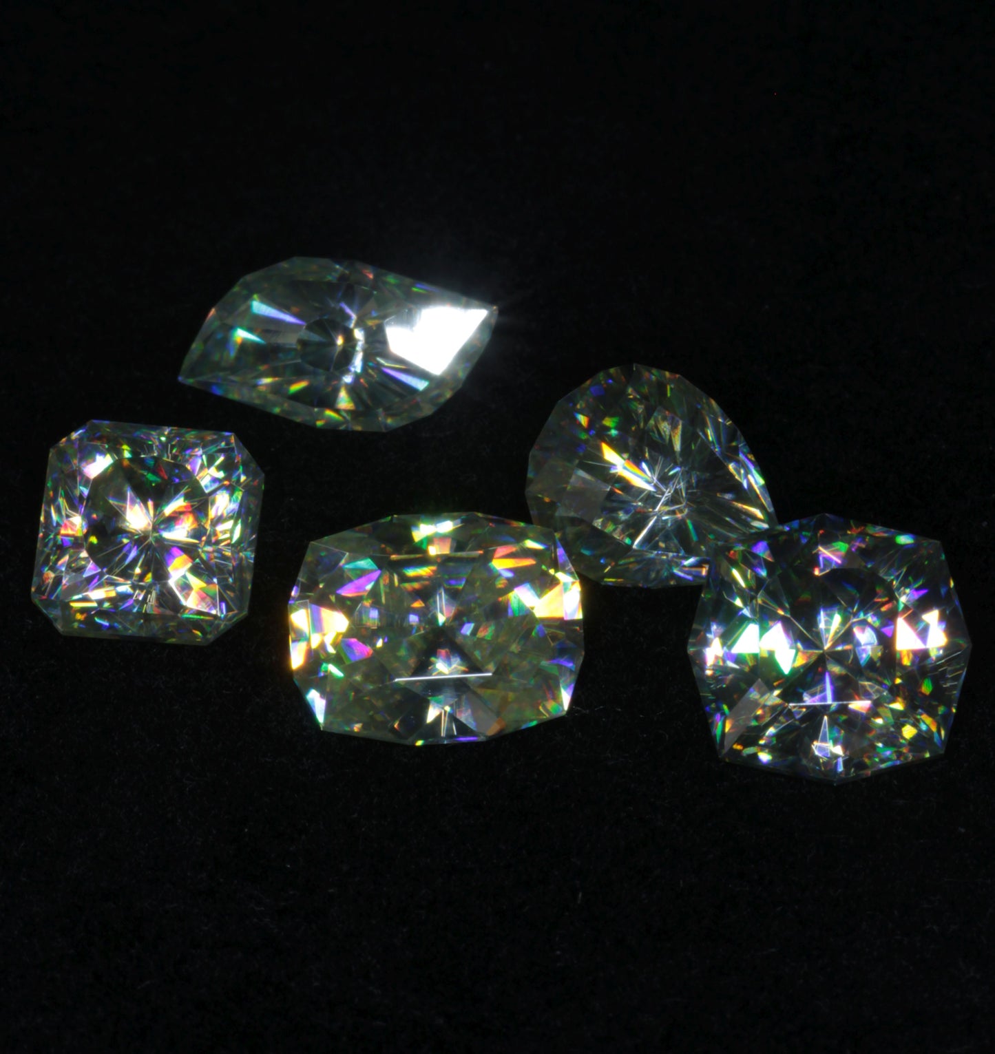 Five faceted white rutile stones showing dispersion
