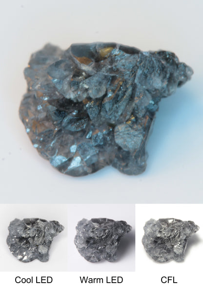 Synthetic Flux Playbutton Sapphire Cluster Gemstone Grown by Gems of Science on a white background showing color shift under different lighting