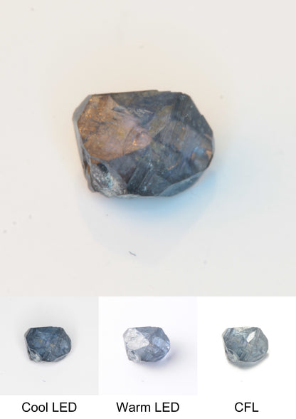 Synthetic Flux Playbutton Sapphire Gemstone Grown by Gems of Science on a white background showing color shift under different lighting