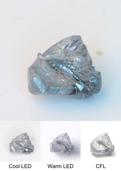 Synthetic Flux Playbutton Sapphire Gemstone Grown by Gems of Science on a white background showing color shift under different lighting