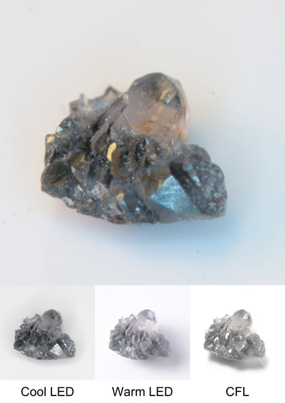 Synthetic Flux Playbutton Sapphire Gemstone Grown by Gems of Science on a white background showing color shift under different lighting