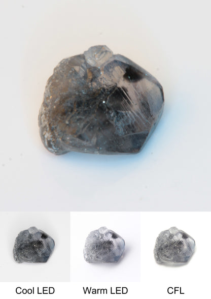 Synthetic Flux Playbutton Sapphire Gemstone Grown by Gems of Science on a white background showing color shift under different lighting