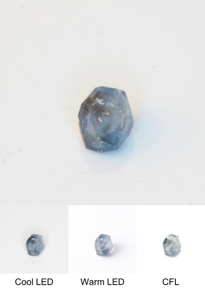 Synthetic Flux Playbutton Sapphire Gemstone Grown by Gems of Science on a white background showing color shift under different lighting