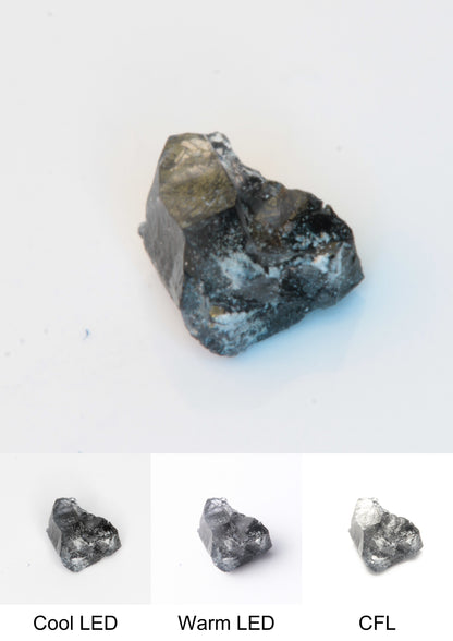 Synthetic Flux Playbutton Sapphire Gemstone Grown by Gems of Science on a white background showing color shift under different lighting