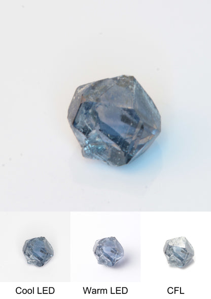 Synthetic Flux Playbutton Sapphire Gemstone Grown by Gems of Science on a white background showing color shift under different lighting