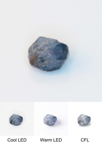 Synthetic Flux Playbutton Sapphire Gemstone Grown by Gems of Science on a white background showing color shift under different lighting