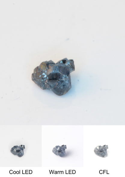 Synthetic Dark Core Flux Playbutton Sapphire Cluster Gemstone Grown by Gems of Science on a white background showing color shift under different lighting