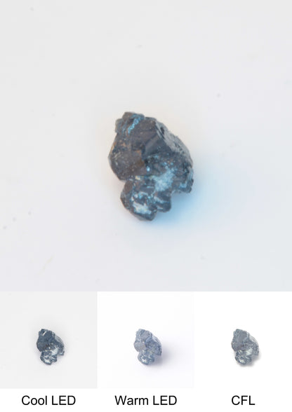 Synthetic Flux Playbutton Sapphire Cluster Gemstone Grown by Gems of Science on a white background showing color shift under different lighting