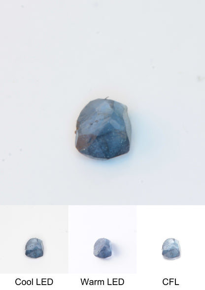 Synthetic Flux Playbutton Sapphire Gemstone Grown by Gems of Science on a white background showing color shift under different lighting