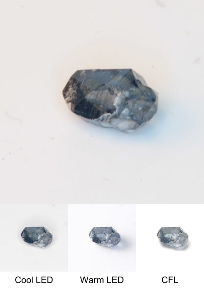 Synthetic Flux Playbutton Sapphire Gemstone Grown by Gems of Science on a white background showing color shift under different lighting