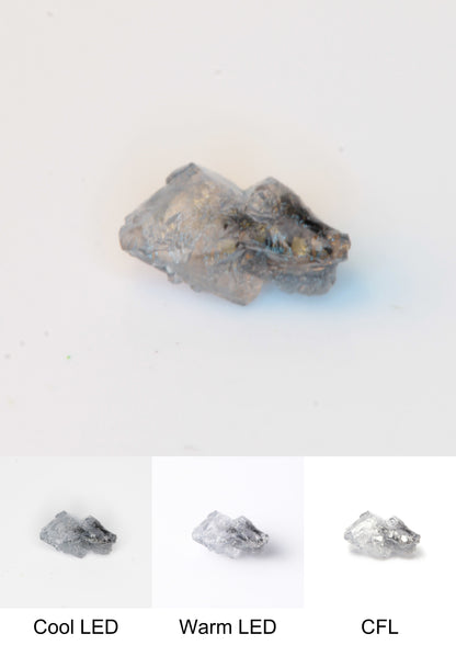 Synthetic Flux Playbutton Sapphire Gemstone Grown by Gems of Science on a white background showing color shift under different lighting