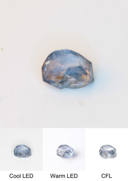 Synthetic Flux Playbutton Sapphire Gemstone Grown by Gems of Science on a white background showing color shift under different lighting