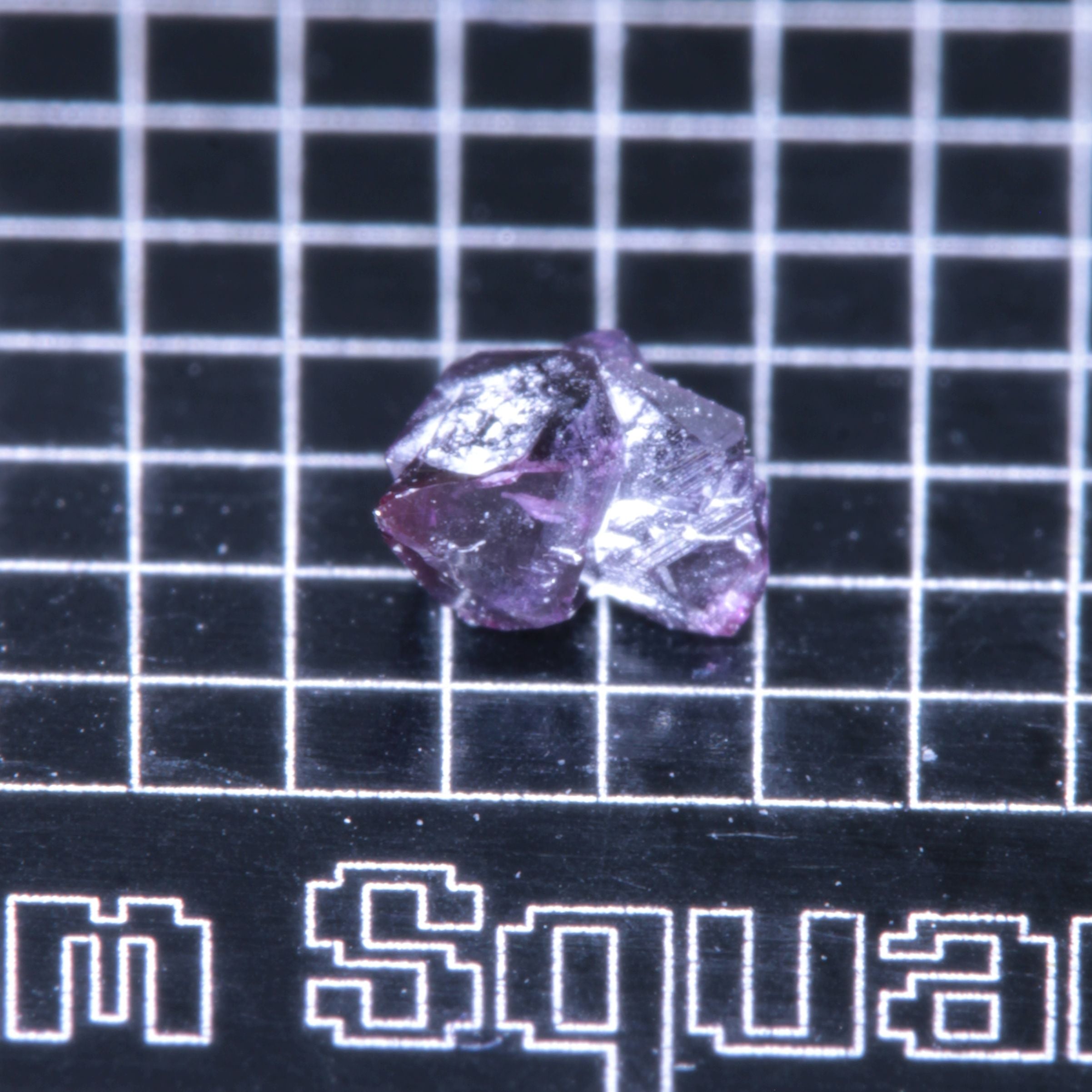 A synthetic ruby crystal on a black grid background