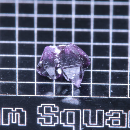 A synthetic ruby crystal on a black grid background