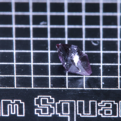 A synthetic ruby crystal on a black grid background