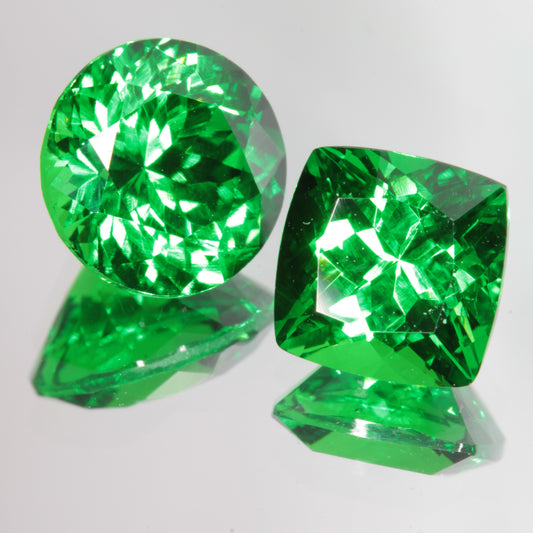 Green Labmade CTH:YAG Gems (Chromium, Thulium, Holmium Yttrium Aluminum Garnet), Round Cut on the left, Cushion Cut on the right