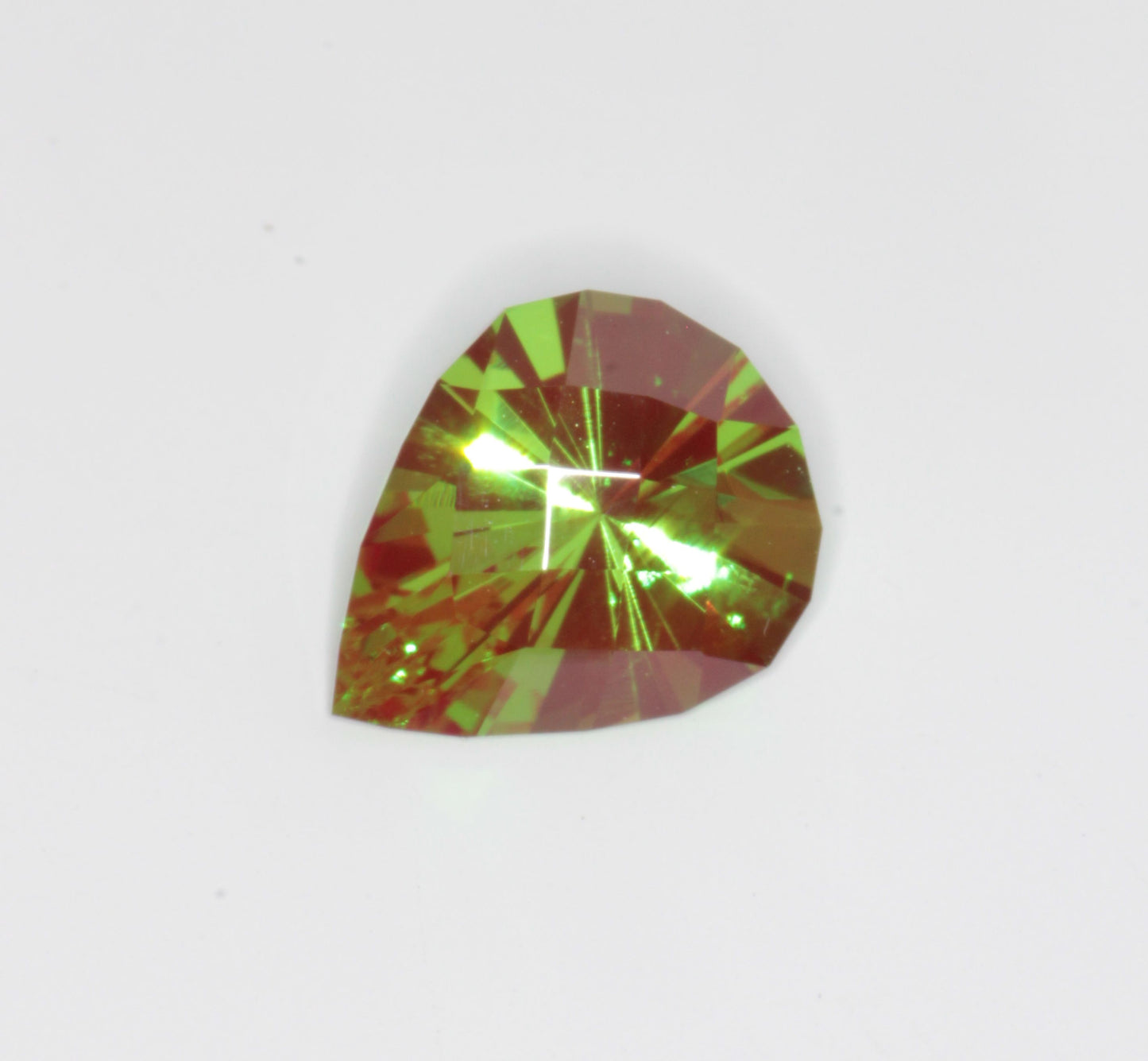 A pear cut green and red Christmas Garnet, Chromium YAG stone on a white background.