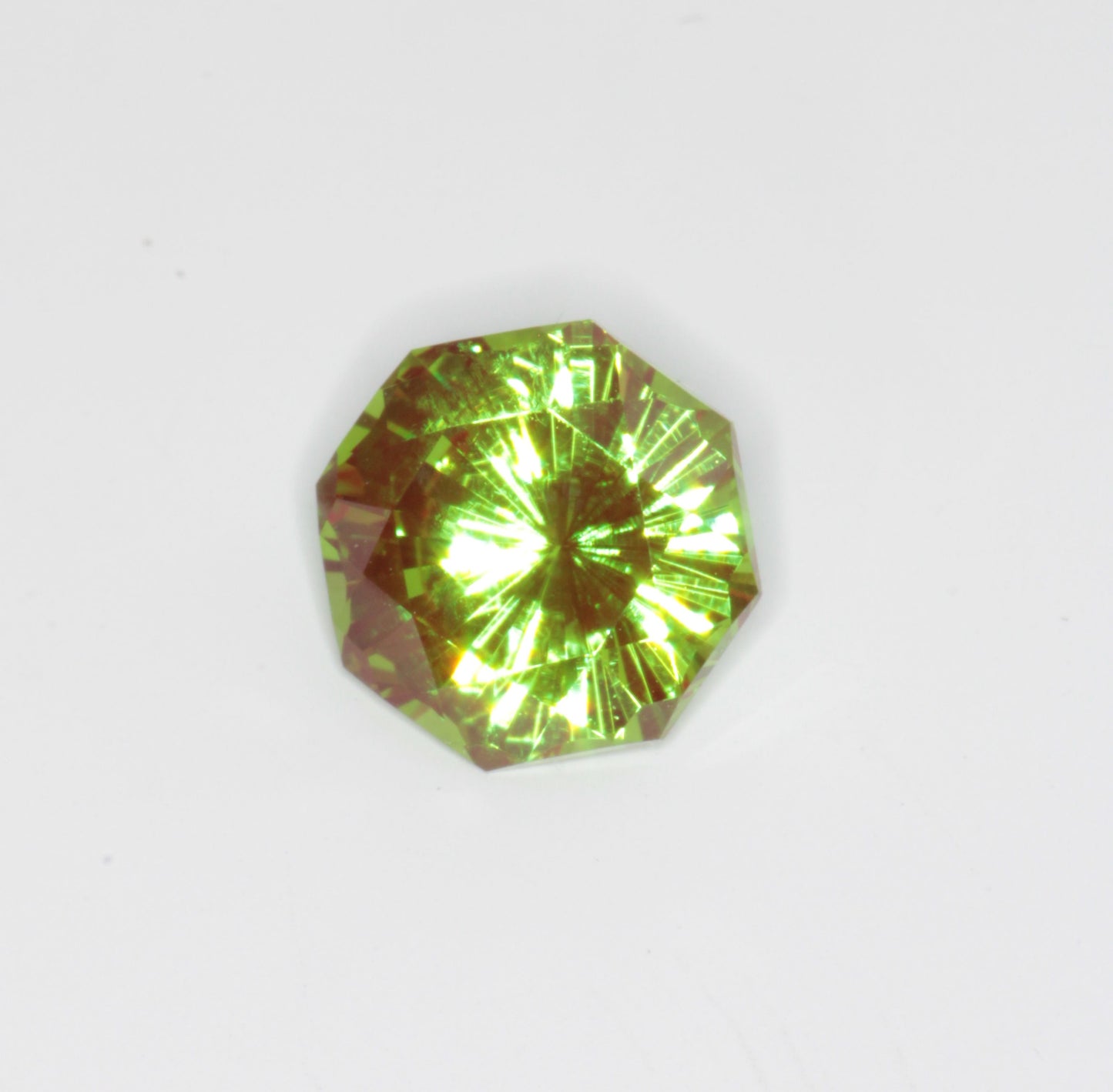 An Octagonal Christmas Garnet on a white background, showing the red and green cr:YAG colors