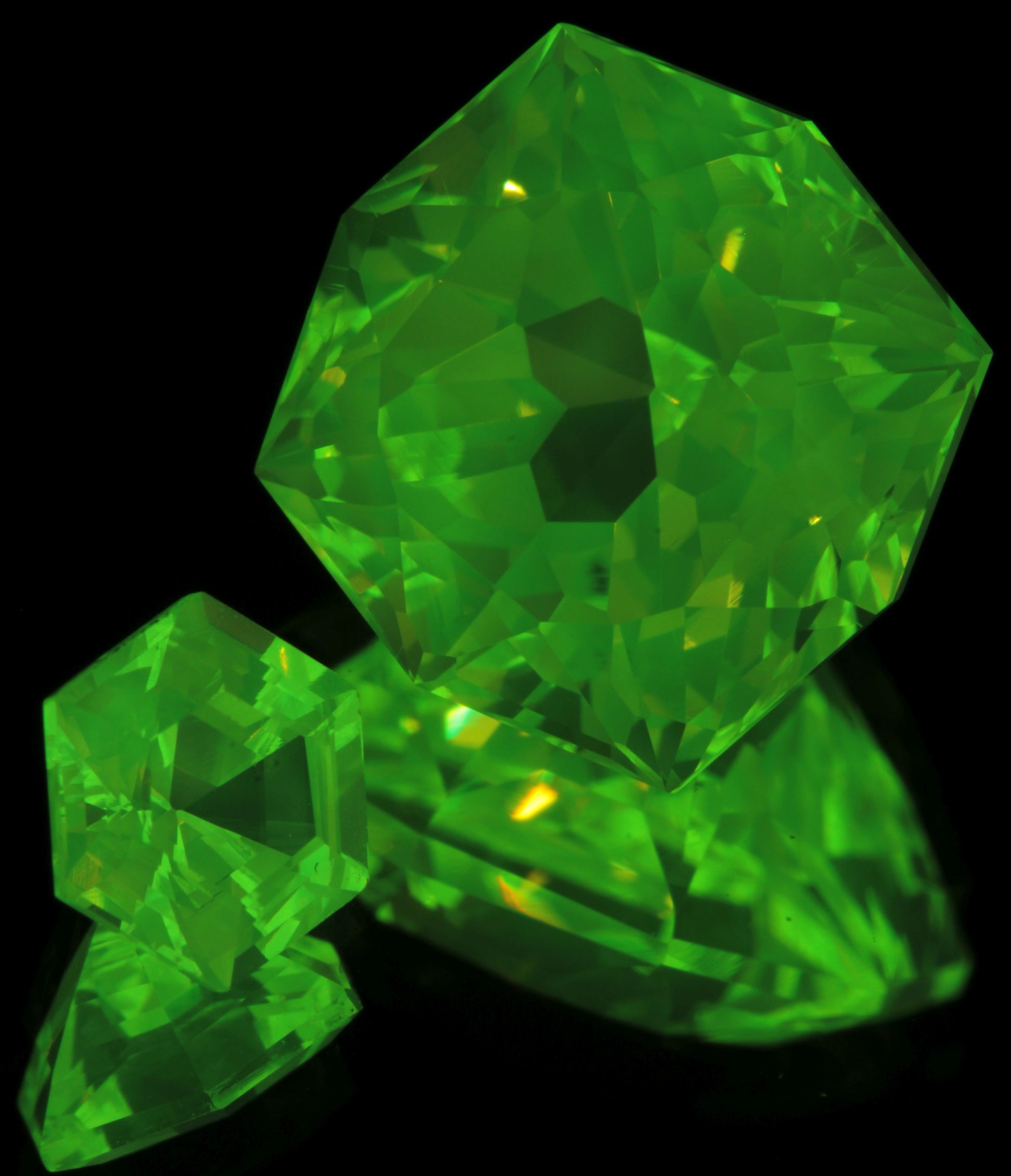 Faceted LuAG Lumogarnets, Green cut Stones under 365nm UV light