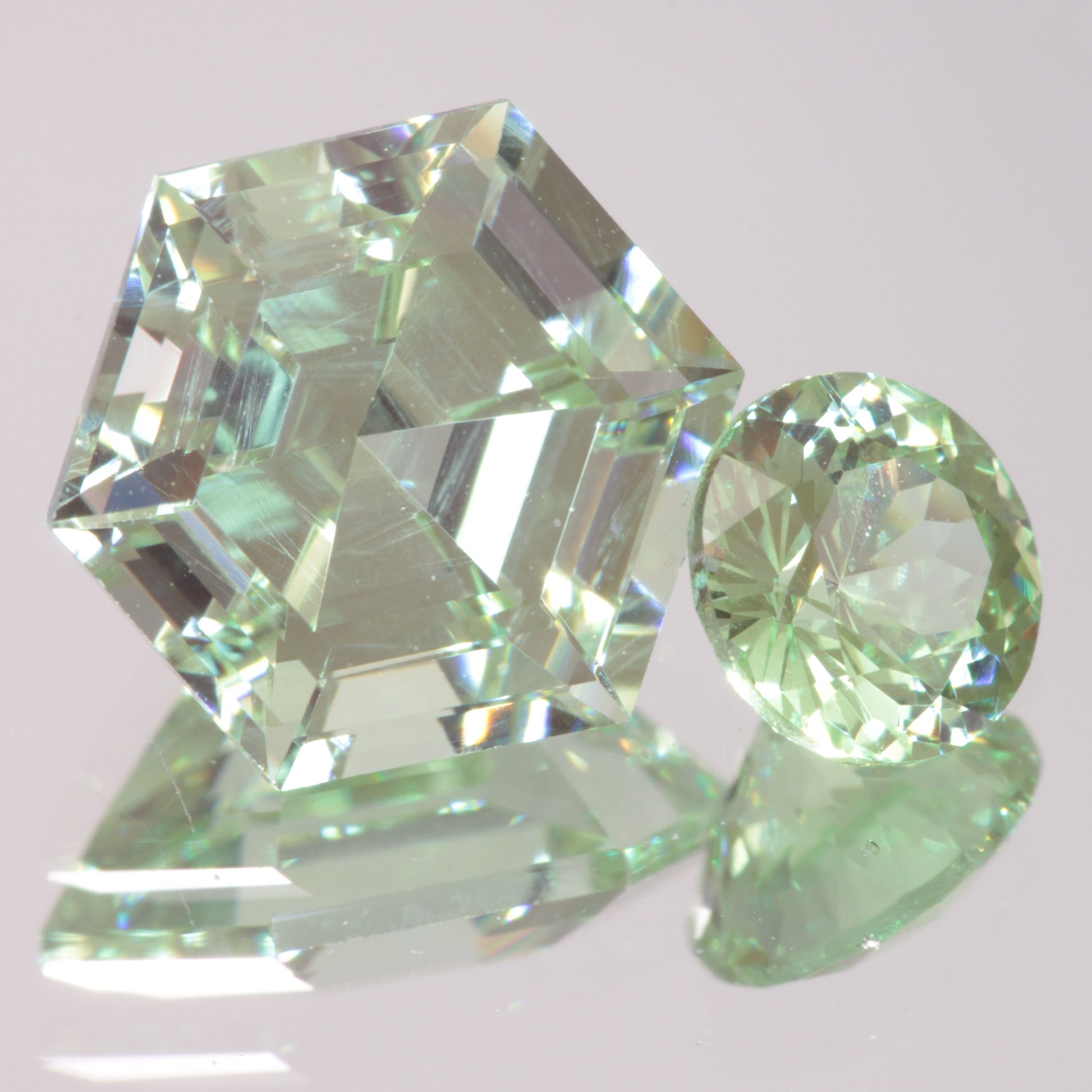 Two faceted light green gemstones made out of Cr+3 :YAG garnet.