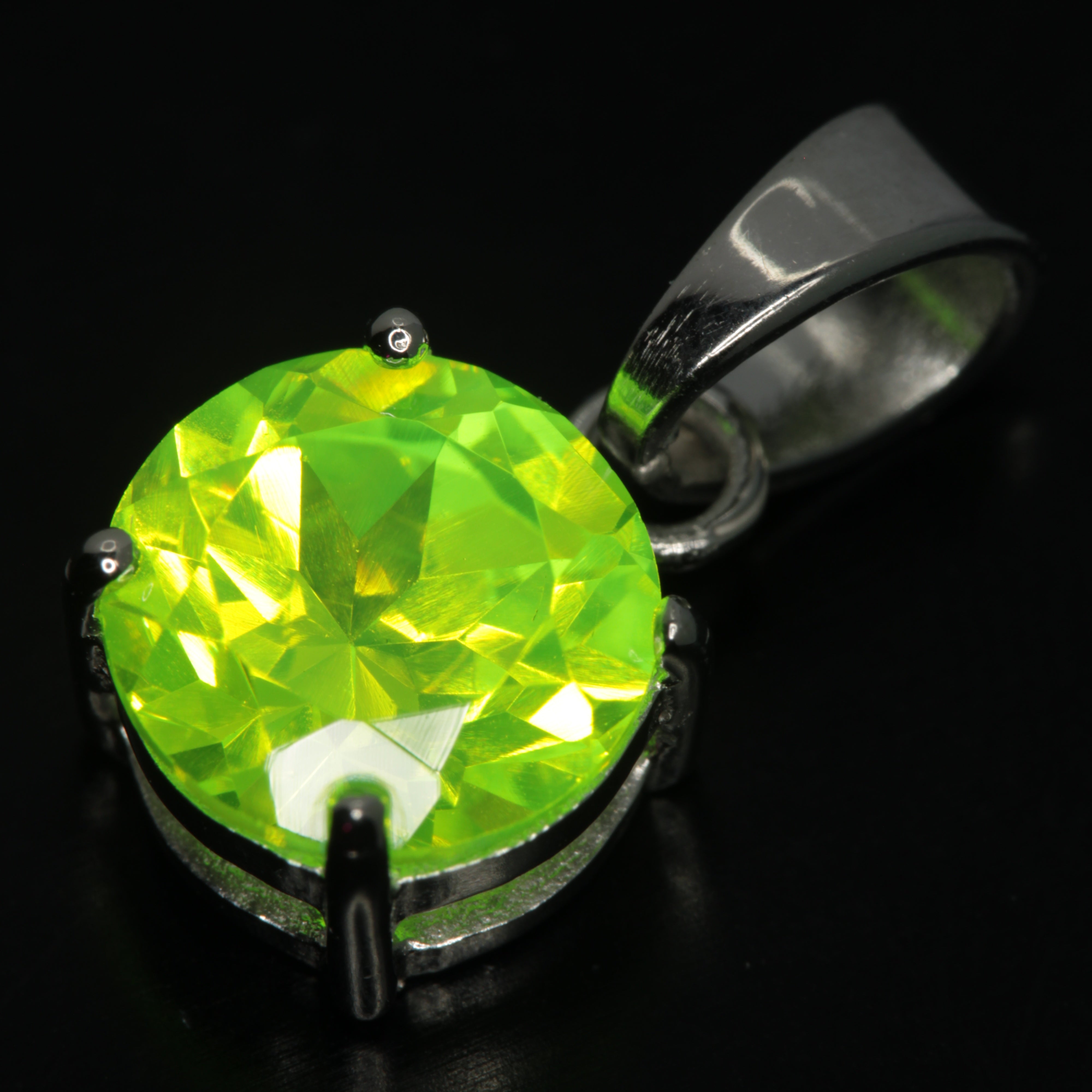 Faceted LuAG Pendant in sterling silver, showing green glow