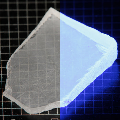 Thin Shard of LSO Gem Rough on a dark background, split between normal light (left) and UV (right) to show blue fluorescent glow.