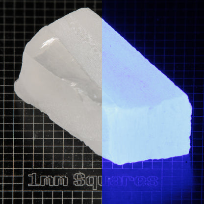 Block of LSO Gem Rough on a dark background, split between normal light (left) and UV (right) to show blue fluorescent glow.
