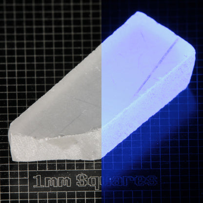 Thin Block of LSO Gem Rough on a dark background, split between normal light (left) and UV (right) to show blue fluorescent glow.