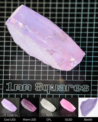 Nd:GGG Flat Piece Gem Rough Under Multiple Lights Showing the Color Change