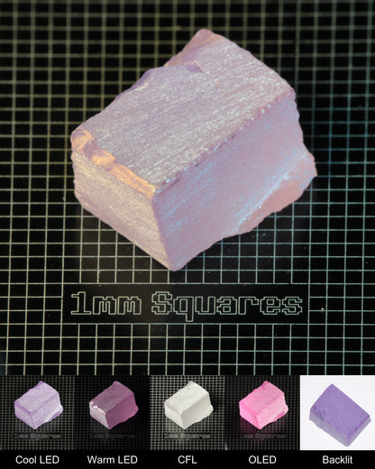 Nd:GGG Cracked Block Gem Rough Under Multiple Lights Showing the Color Change