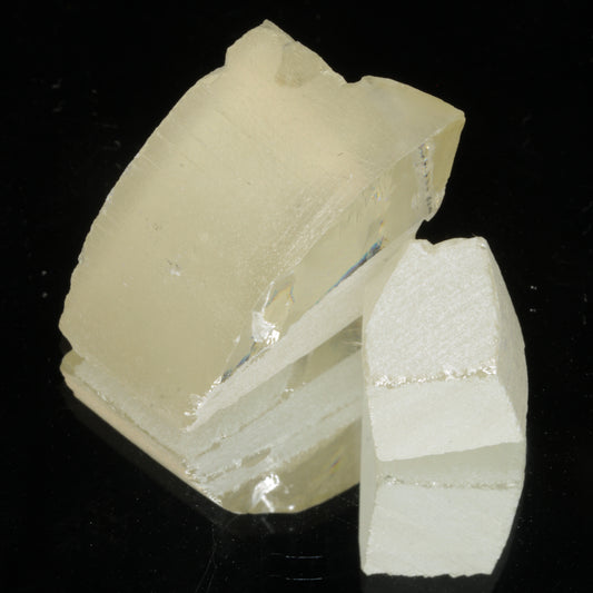 Two pieces of rough strontium titanate (fabulite) for gemcutting on a black background
