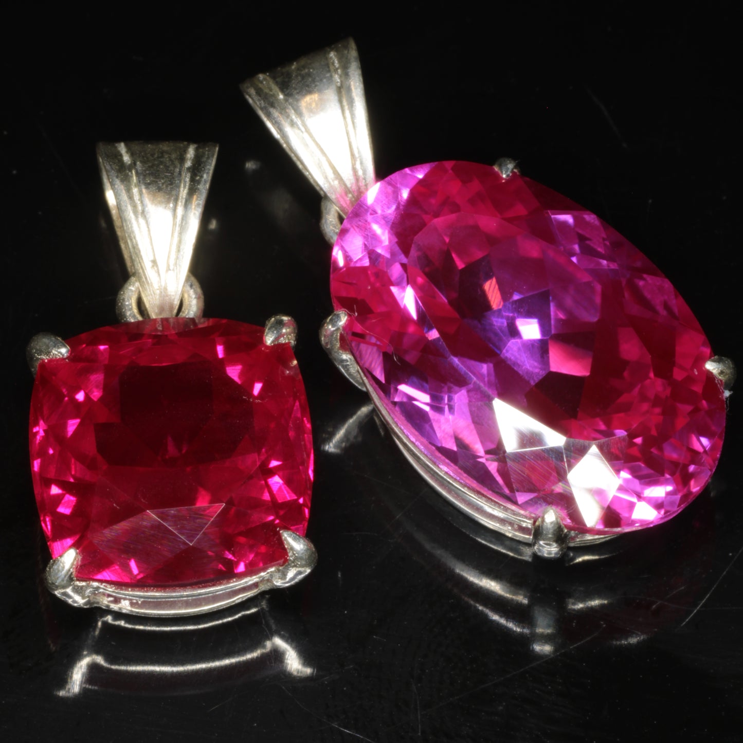 Two faceted lab rubies in sterling silver pendant settings