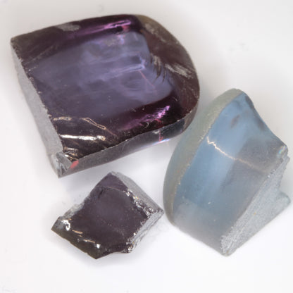 Three pieces of flame fusion sapphire under cool LED lighting showing bluer colors