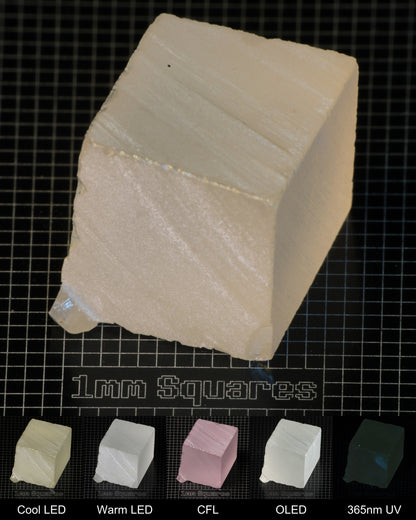 Light Block of Ho:YAG Gem Rough, showing color changes from yellow to pink under different lighting conditions.