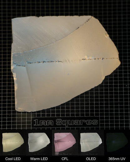 Light Edge of Ho:YAG Gem Rough, showing color changes from yellow to pink under different lighting conditions.