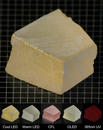 Darker Block of Ho:YAG Gem Rough, showing color changes from yellow to pink under different lighting conditions.