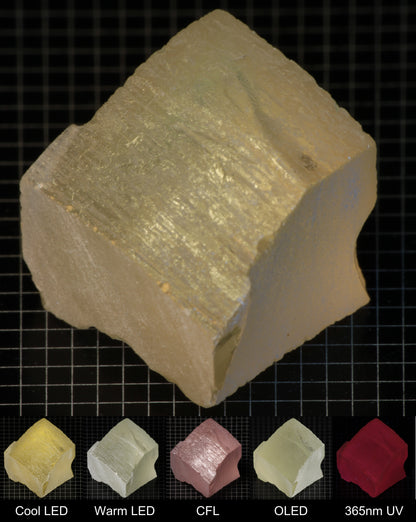 Darker Block of Ho:YAG Gem Rough, showing color changes from yellow to pink under different lighting conditions.