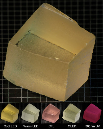 Darker Block of Ho:YAG Gem Rough, showing color changes from yellow to pink under different lighting conditions.