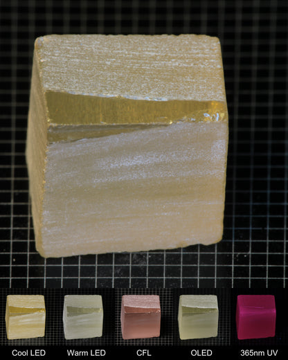 Darker Block of Ho:YAG Gem Rough, showing color changes from yellow to pink under different lighting conditions.