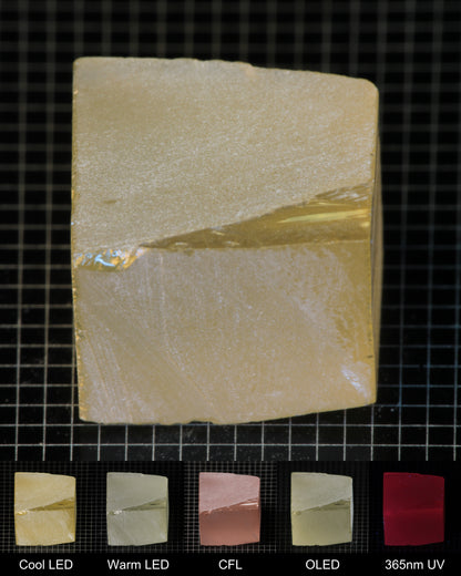 Darker Block of Ho:YAG Gem Rough, showing color changes from yellow to pink under different lighting conditions.