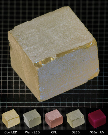 Darker Block of Ho:YAG Gem Rough, showing color changes from yellow to pink under different lighting conditions.