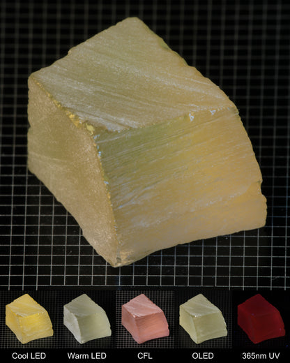 Darker Block of Ho:YAG Gem Rough, showing color changes from yellow to pink under different lighting conditions.