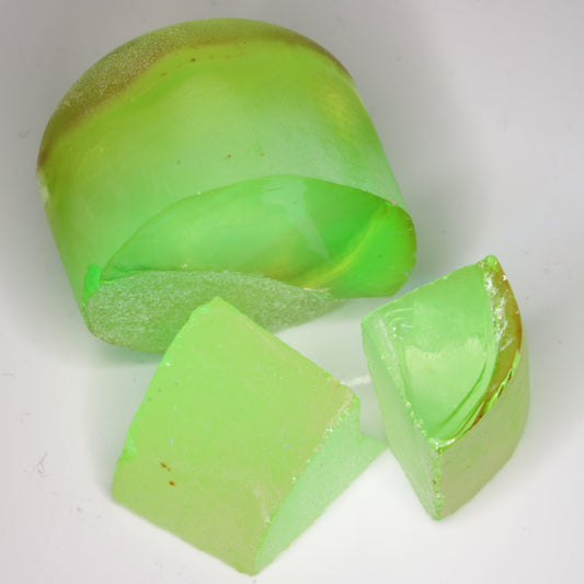 Yellow Flame Fusion Spinel under combined normal LED lighting and 365nm UV, showing the bright green fluorescence